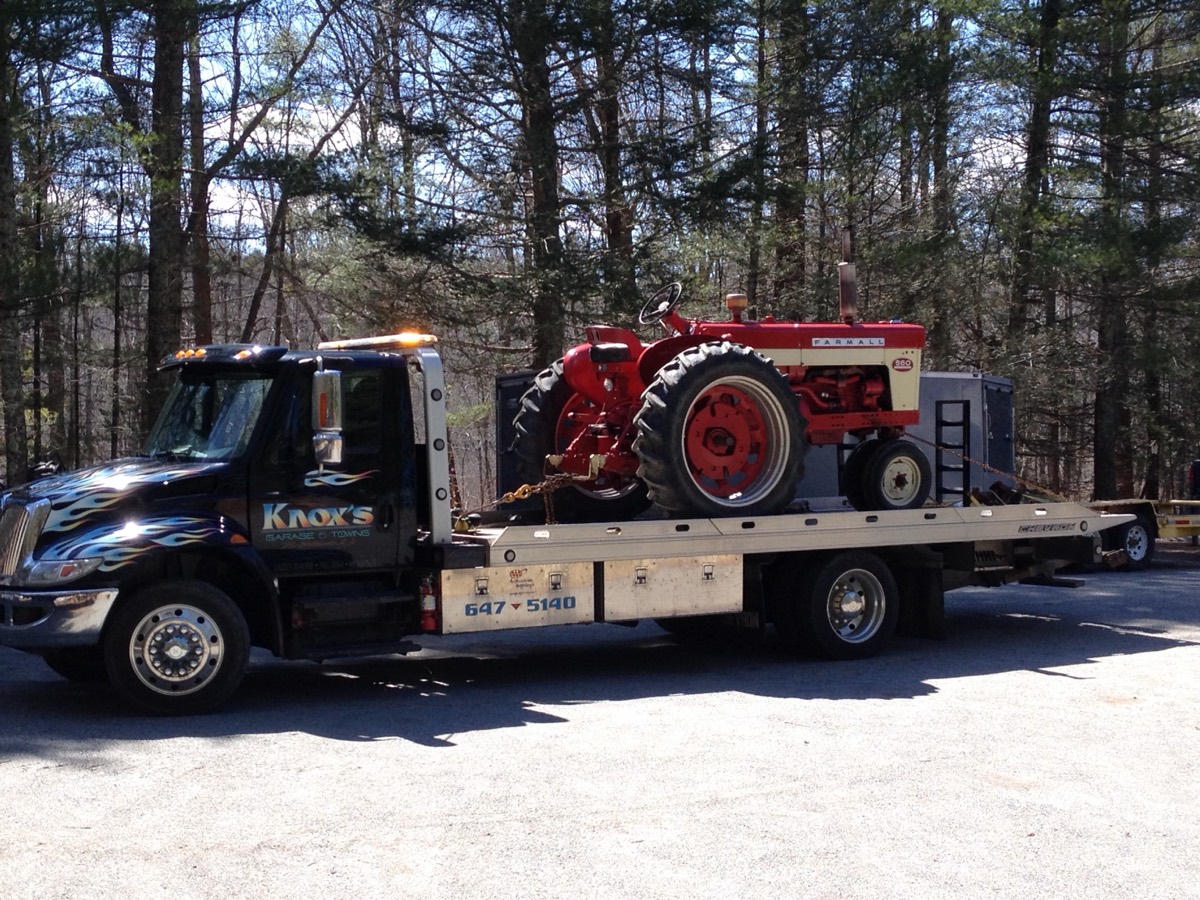 Knox's flatbed hauling a vintage Farmall tractor